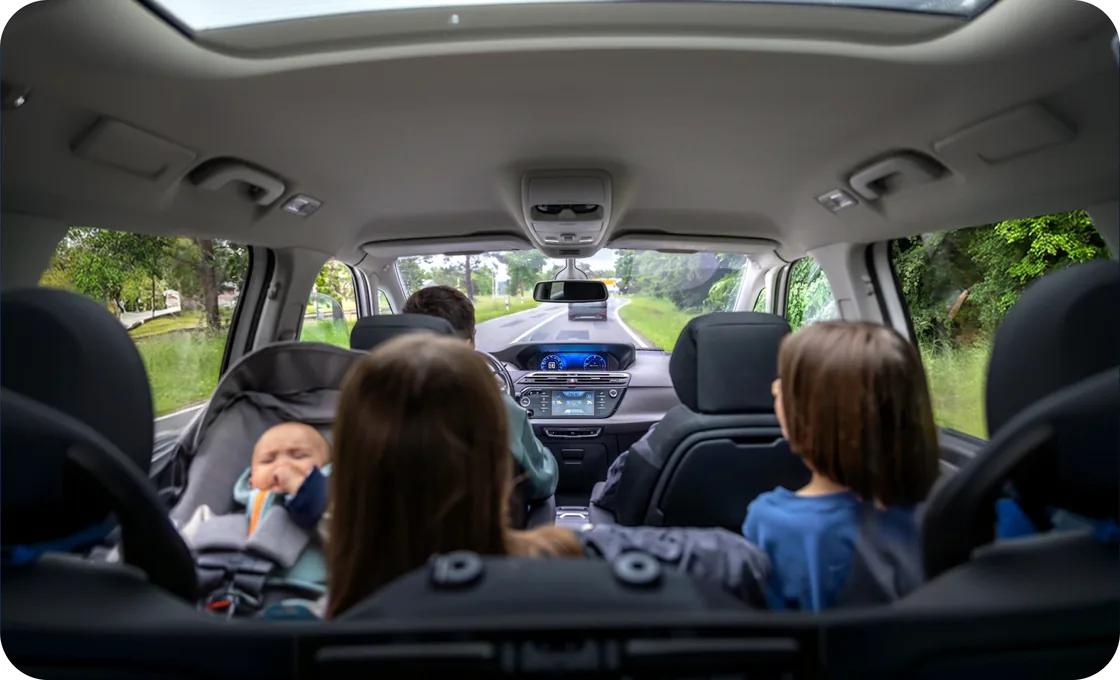 A family on a highway trip, seen from the back seat of a car